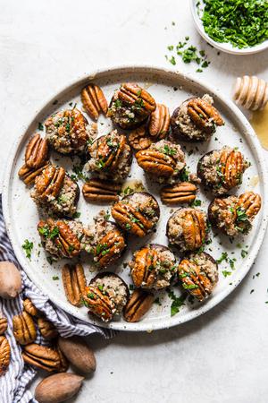a plate with pecan and goat cheese stuffed mushrooms with parsley and honey