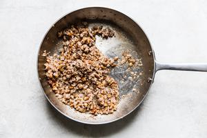 chopped mushroom caps, minced garlic and chopped pecans sautéed in a pan.
