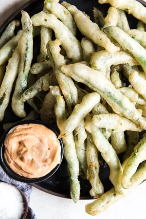 tempura green beans with curry mayonnaise on a platter