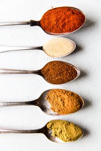 cumin, chili powder, garlic powder, cinnamon and smoked paprika on spoons