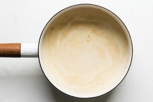 heavy cream with vanilla and spices in a white saucepan