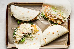 4 apple and caramelized onion spinach fontina quesadillas on a baking sheet with parchment.