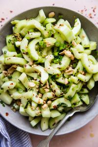 asian cucumber salad in a large bowl with a spoon