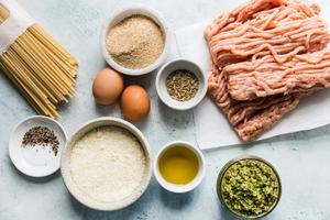 Ingredients for baked chicken meatballs with broccoli pesto pasta in small bowls