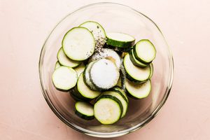 sliced raw zucchini getting prepped to make crispy roasted zucchini with parmesan