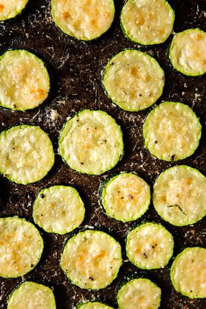 crispy roasted zucchini with parmesan on a baking sheet