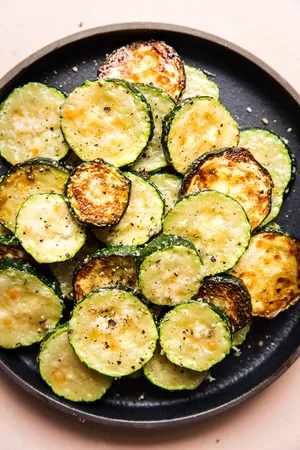 a plate of crispy, golden delicious roasted zucchini with parmesan