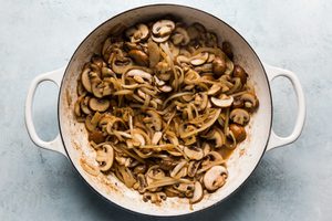 onions, mushrooms and garlic being cooked in butter in a skillet to use as a base in beef stroganoff