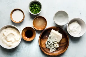 mayonnaise, sour cream, Worcestershire, lemon juice, vinegar, chives, heavy cream, and blue cheese in prep bowls
