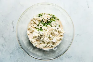 mayonnaise, sour cream, Worcestershire, lemon juice, vinegar, chives, heavy cream, and blue cheese in a glass bowl