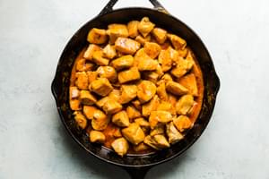 buffalo chicken bites in a cast iron skillet in buffalo sauce