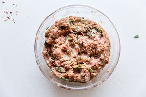 ground turkey, garlic, ginger, chopped basil, salt, red pepper flakes and chopped green onions mixed together in a bowl