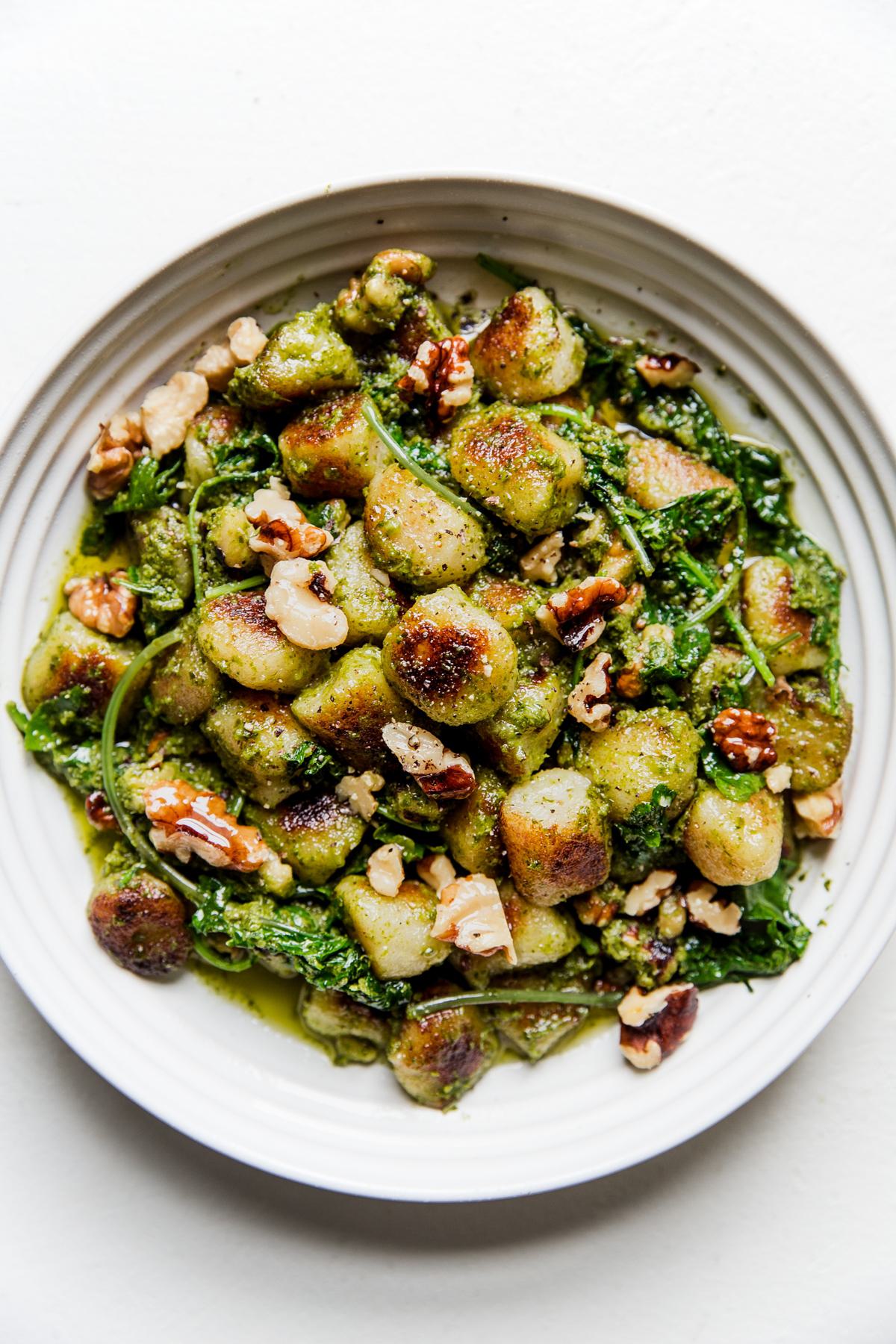 vegan cauliflower gnocchi with Kale-Cashew pesto in a white bowl