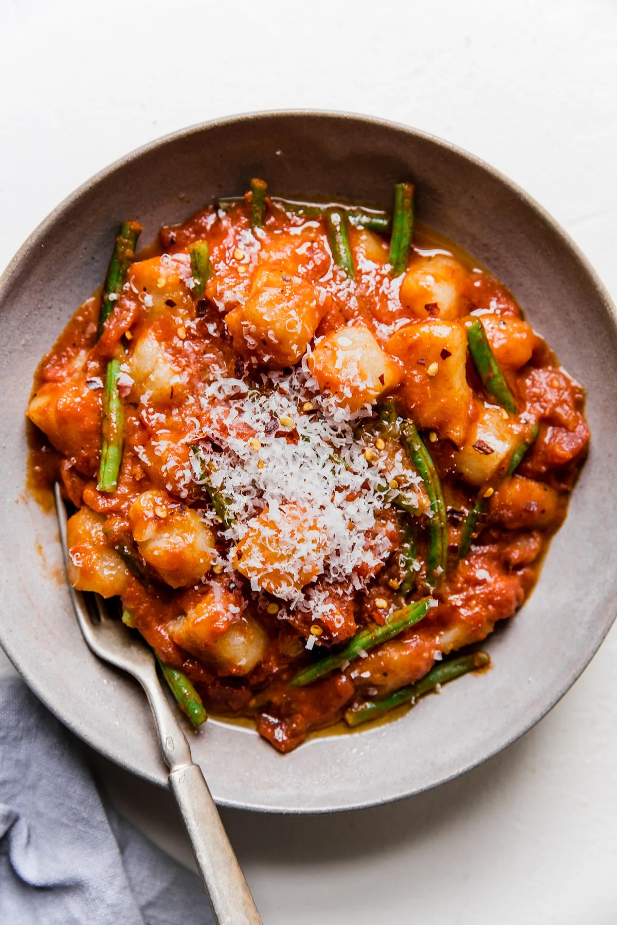 bowl of vodka sauce and green bean cauliflower gnocchi topped with parmesan cheese