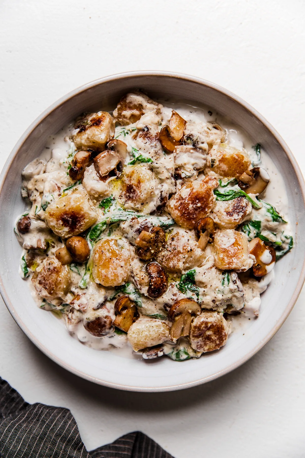 white bowl of mushroom alfredo cauliflower gnocchi