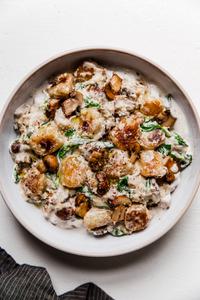 white bowl of mushroom alfredo cauliflower gnocchi