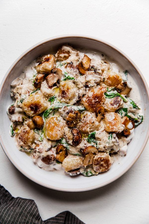 white bowl of mushroom alfredo cauliflower gnocchi