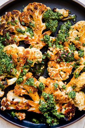 close up of cauliflower steaks with walnut kale pesto
