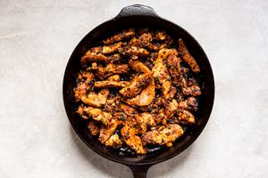 cast iron skillet of cooked fajita chicken