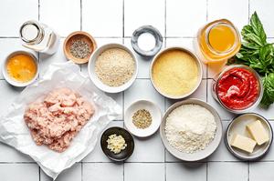 ground chicken, eggs, parmesan, basil, bread crumbs, marinara sauce and spices in bowls to make chicken meatballs