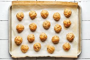 homemade baked chicken meatballs on a parchment lined baking sheet