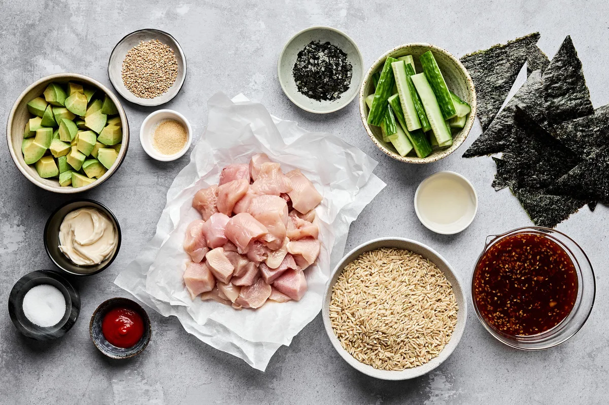 Ingredients neatly arranged to make chicken teriyaki sushi bowls, including sushi rice, teriyaki chicken and sriracha mayo