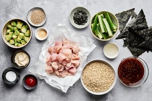 Ingredients neatly arranged to make chicken teriyaki sushi bowls, including sushi rice, teriyaki chicken and sriracha mayo