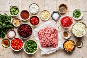 ground beef, onion, bell pepper, spices, kidney beans, beef bouillon cubes, canned tomatoes, and tomato paste in prep bowls