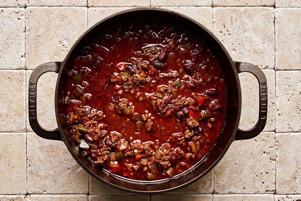 a pot of chili con carne made with ground beef, onion, bell pepper, spices, kidney beans, tomatoes, and tomato paste
