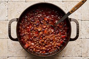 a pot of chili con carne made with ground beef, onion, bell pepper, spices, kidney beans, tomatoes, and tomato paste
