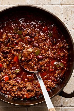 a pot of chili con carne made with ground beef, onion, bell pepper, spices, kidney beans, tomatoes, and tomato paste