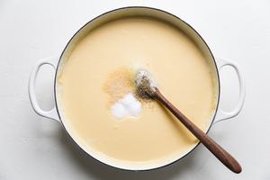 seasoning being added to cheese sauce for Classic Baked Macaroni And Cheese