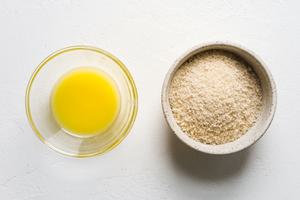 a bowl of melted butter and a bowl of panko bread crumbs