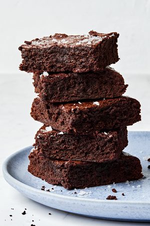 a plate of classic fudge brownies in a stack on a plate