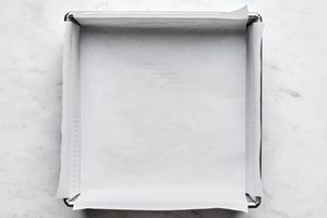 an 8x8 baking dish greased and lined with parchment paper for making classic fudgy brownies