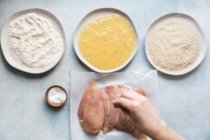 raw chicken being salted for crispy panko chicken