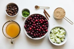 ingredients laid out for homemade cranberry chutney apples, brown sugar, figs, apple cider cinnamon, jalapeño