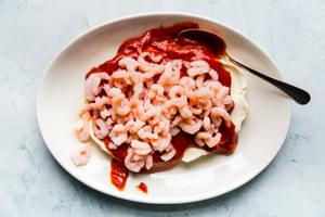 cocktail sauce and shrimp over cream cream cheese on a white platter