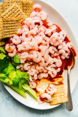 cream cheese shrimp dip on a platter with triskets and celery