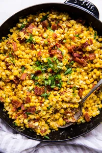 dairy free creamed corn in a skillet made with bacon and green onions