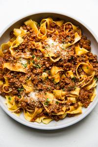 large bowl of homemade bolognese with pasta and fresh parmesan