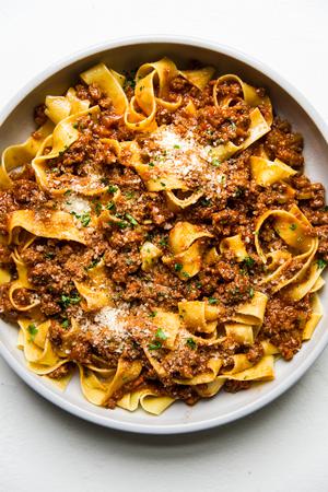 large bowl of homemade bolognese with pasta and fresh parmesan