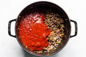 ground beef with vegetables in a pot mixed with jarred tomato sauce
