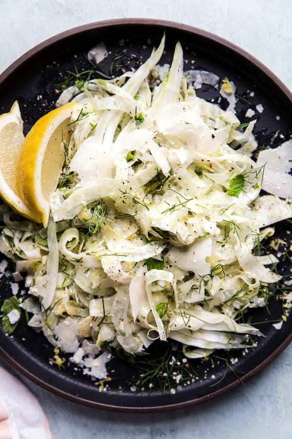 easy shaved fennel salad with parmesan cheese and fresh herbs on a plate