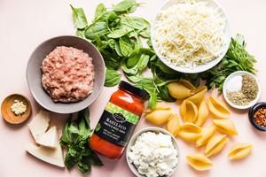 ground chicken, ricotta, mozzarella, Parmesan, basil, spinach , marinara and pasta shells in bowls to make stuffed shells