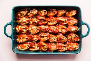 ground chicken and ricotta stuffed pasta shells in a pan covered with marinara sauce