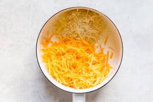 milk, parmesan and cheddar cheese in a sauce pan for stovetop mac and cheese
