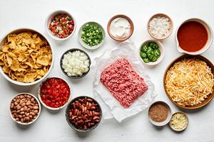 ground beef, kidney & pinto beans, cheese, enchilada sauce, tomatoes and taco seasoning in prep bowls to make frito pie