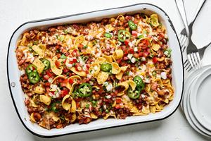 frito pie made with ground beef, kidney & pinto beans, topped with onion, green onion, jalapenos, and pico de gallo