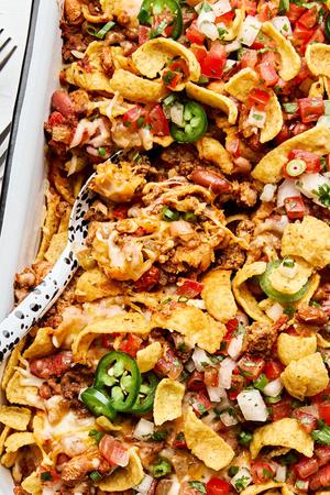 frito pie made with ground beef, kidney & pinto beans, topped with onion, green onion, jalapenos, and pico de gallo